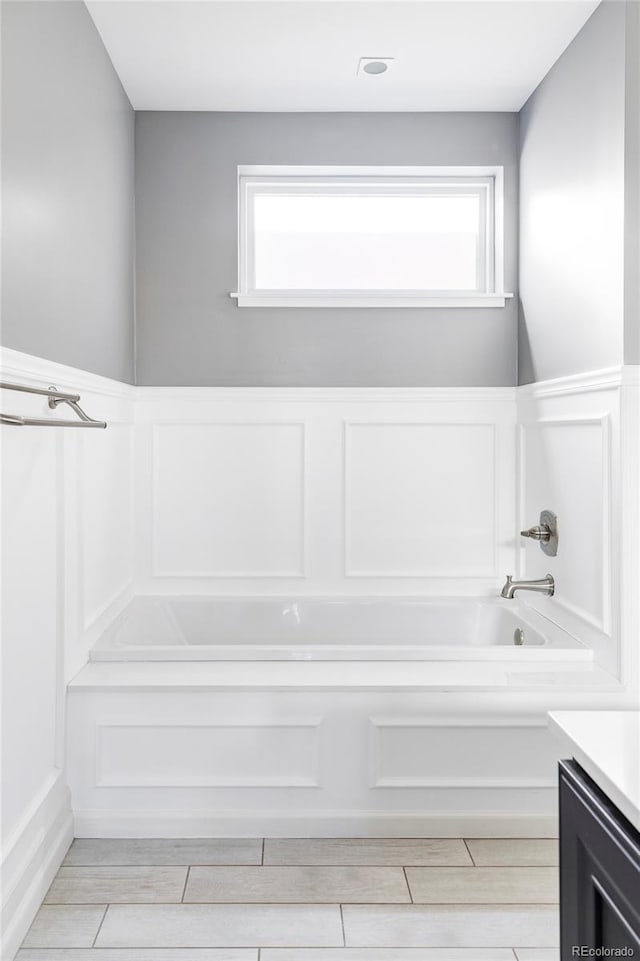 bathroom with a tub to relax in and vanity