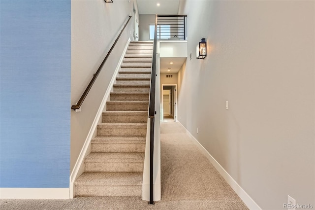 stairs featuring carpet flooring and a towering ceiling