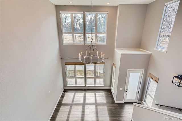 foyer featuring an inviting chandelier, a high ceiling, and dark hardwood / wood-style flooring