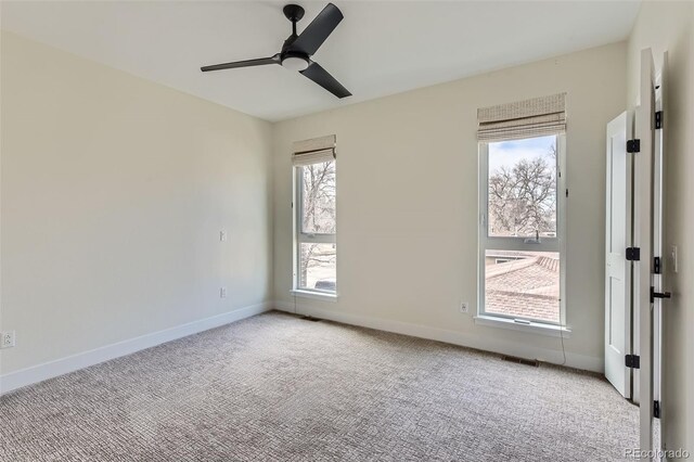 empty room with ceiling fan, light carpet, and a healthy amount of sunlight