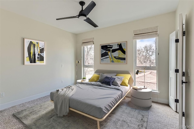 bedroom featuring ceiling fan, multiple windows, and carpet flooring