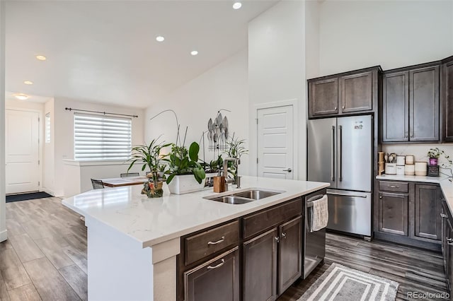 10095 E 59th Ave, Denver, CO 80238 - kitchen featuring stainless steel appliances, dark wood-style floors, dark brown cabinetry, a center island with sink, and recessed lighting