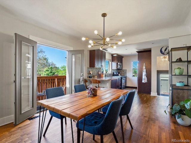 dining room featuring a chandelier, baseboards, and wood finished floors