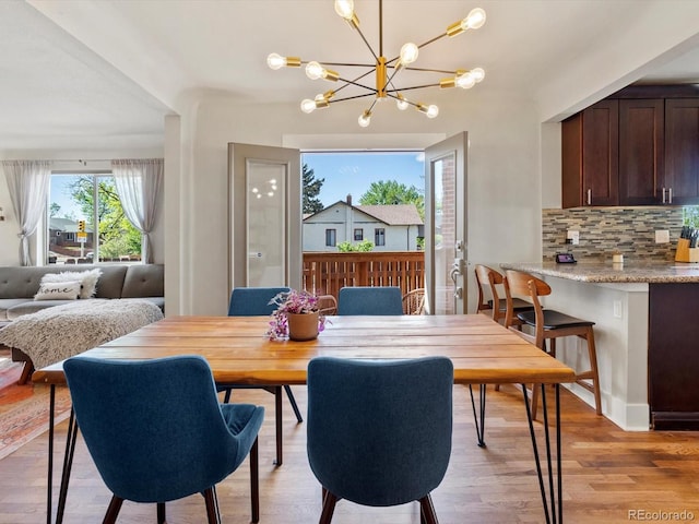 dining area with a chandelier and light wood-style flooring