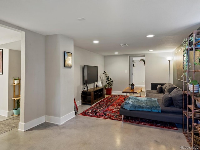 living room featuring concrete floors, recessed lighting, and baseboards