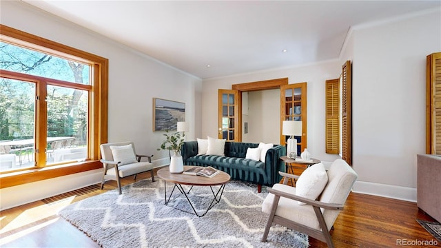 living room with ornamental molding, plenty of natural light, and wood-type flooring