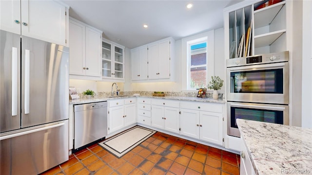 kitchen with white cabinets, sink, stainless steel appliances, and dark tile floors