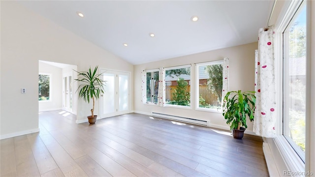 unfurnished room featuring vaulted ceiling, a baseboard heating unit, and hardwood / wood-style floors