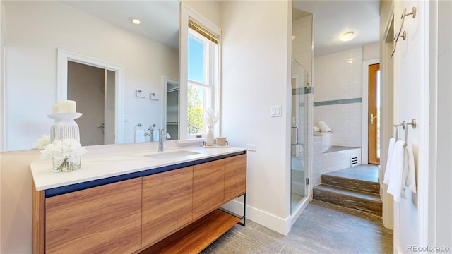 bathroom with a shower with shower door and large vanity