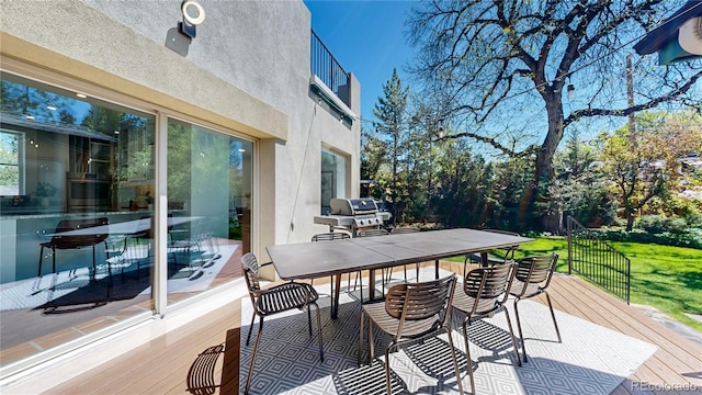 wooden terrace featuring grilling area and a lawn