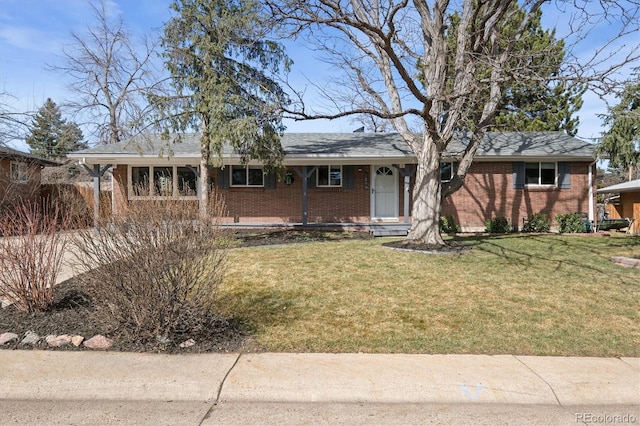 single story home featuring brick siding and a front yard