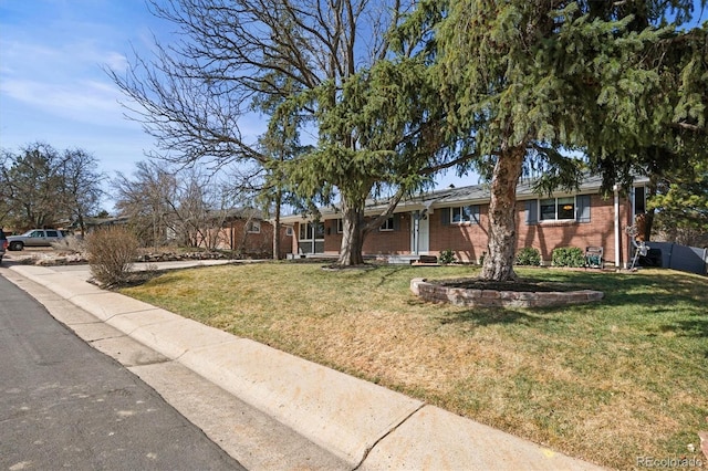 single story home featuring a front lawn and brick siding