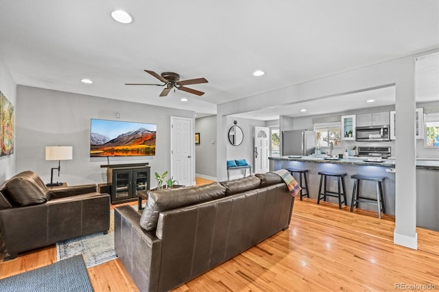 living area with recessed lighting, baseboards, light wood-style floors, and ceiling fan