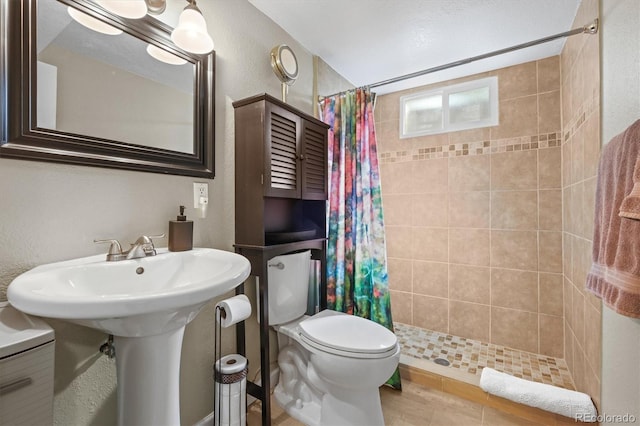 full bath featuring a shower stall, toilet, and a textured wall