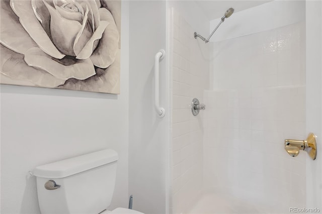 bathroom featuring a tile shower and toilet