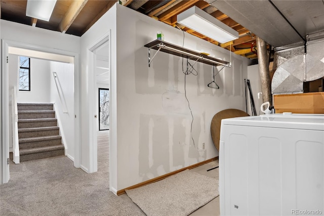 clothes washing area with light carpet and washer / dryer