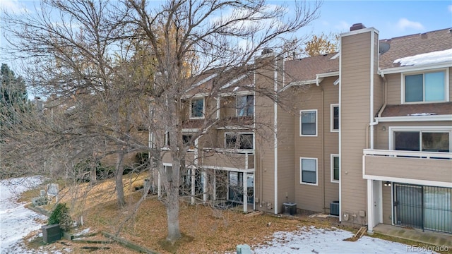 snow covered property featuring central AC unit