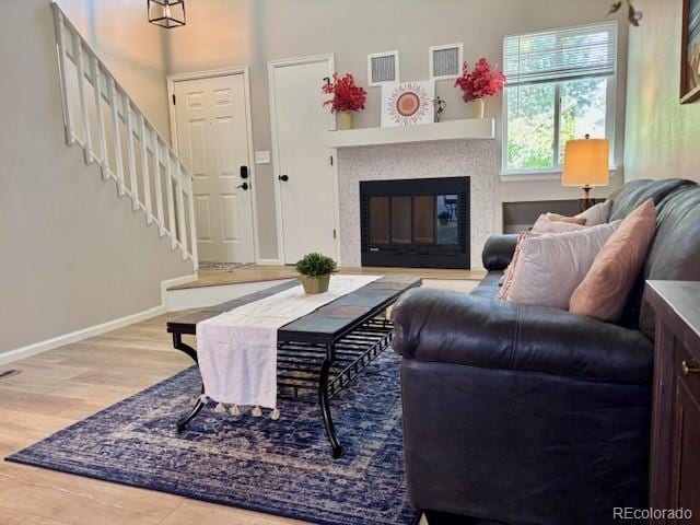 6895 W 84th Way Unit 4, Arvada, CO 80003 - living area featuring wood finished floors, a glass covered fireplace, baseboards, and stairs