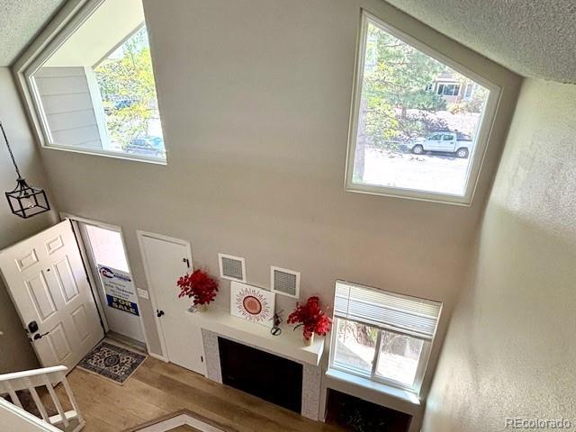 6895 W 84th Way Unit 4, Arvada, CO 80003 - foyer with wood finished floors, healthy amount of natural light, a towering ceiling, and a textured ceiling