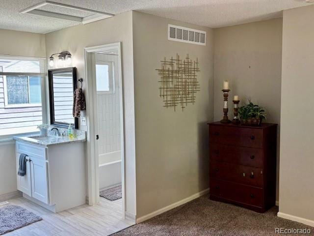 6895 W 84th Way Unit 4, Arvada, CO 80003 - bathroom featuring healthy amount of natural light, vanity, a bath, a textured ceiling, and baseboards