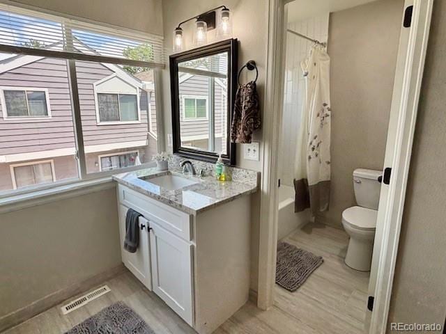 6895 W 84th Way Unit 4, Arvada, CO 80003 - bathroom with vanity, toilet, wood finished floors, shower / tub combo, and baseboards