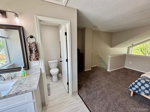 6895 W 84th Way Unit 4, Arvada, CO 80003 - bathroom with toilet, vanity, baseboards, and a textured ceiling