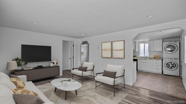 28571/2 Teller Ave, Grand Junction, CO 81501 - living room with stacked washer / dryer, arched walkways, recessed lighting, and light wood-style flooring