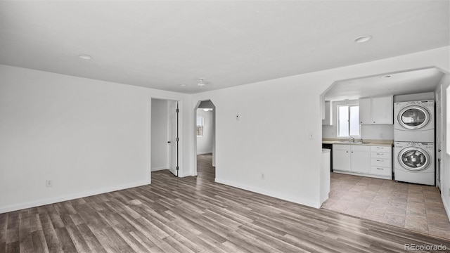 28571/2 Teller Ave, Grand Junction, CO 81501 - unfurnished living room featuring stacked washer and clothes dryer, arched walkways, light wood-style floors, and recessed lighting
