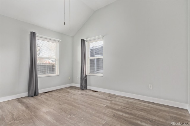 unfurnished room with light hardwood / wood-style floors and vaulted ceiling