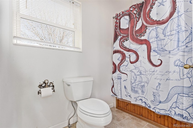 bathroom with tile patterned floors, curtained shower, and toilet