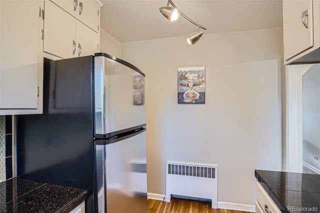 1523 Ivy St Unit 6, Denver, CO 80220 - kitchen featuring radiator, freestanding refrigerator, white cabinets, wood finished floors, and tile counters