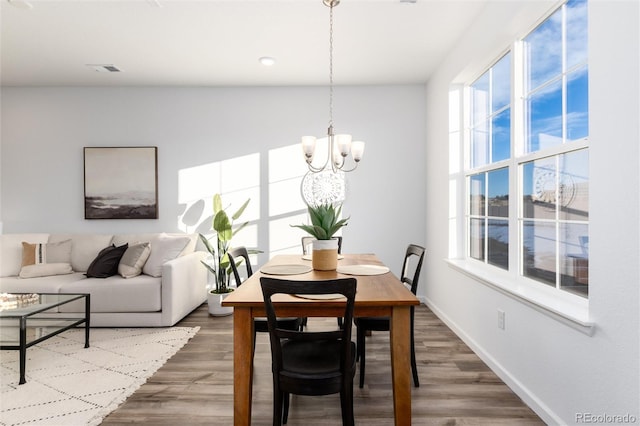 dining space featuring hardwood / wood-style floors and a notable chandelier