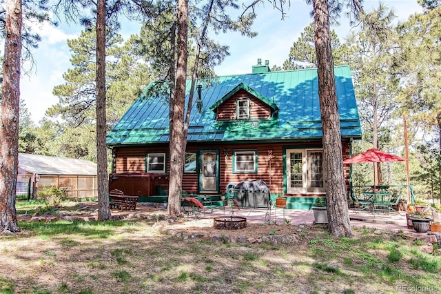 5030 Cedar Way, Elizabeth, CO 80107 - rear view of house with an outdoor fire pit, metal roof, a patio, and a standing seam roof