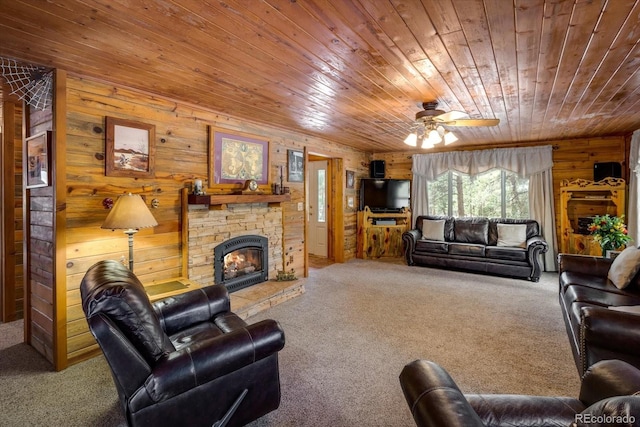 5030 Cedar Way, Elizabeth, CO 80107 - living room featuring carpet flooring, wooden ceiling, wooden walls, a ceiling fan, and a stone fireplace