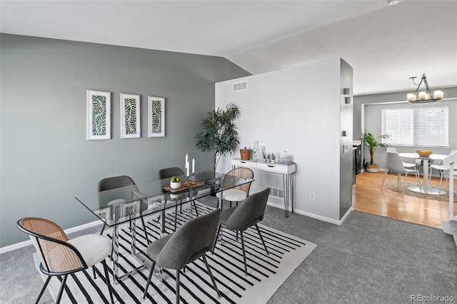 carpeted dining area featuring lofted ceiling, visible vents, a chandelier, and baseboards