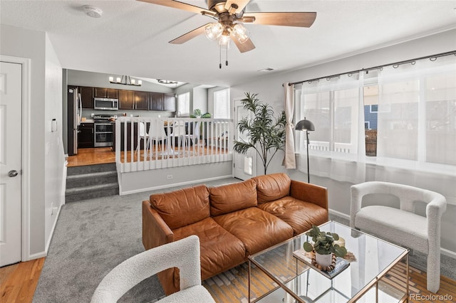 living room with visible vents, ceiling fan, a textured ceiling, and baseboards