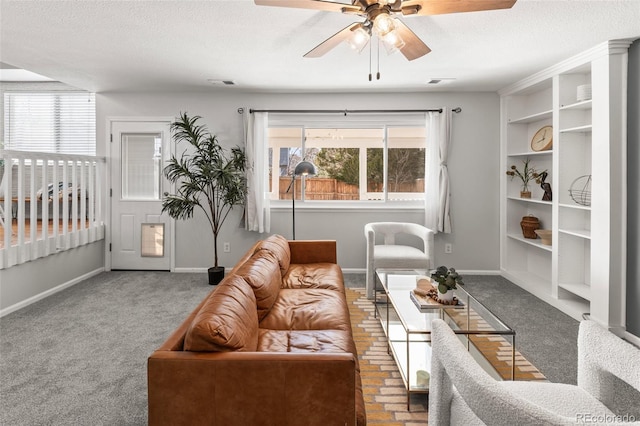 living area featuring carpet floors, a healthy amount of sunlight, visible vents, and a textured ceiling