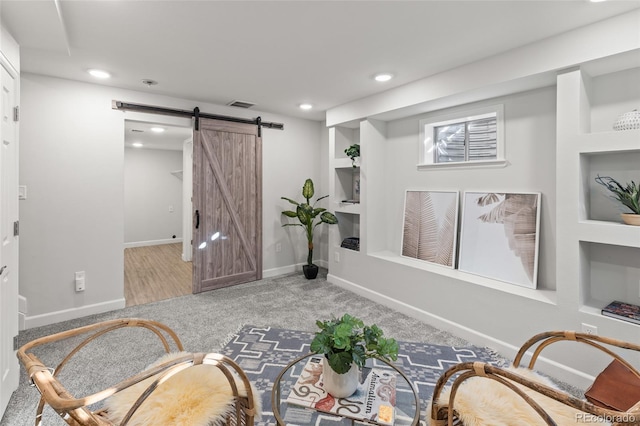 sitting room featuring a barn door, recessed lighting, visible vents, baseboards, and carpet