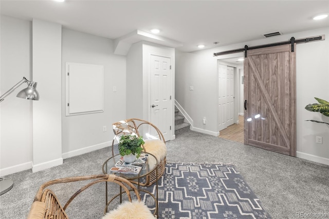 living area with visible vents, stairway, a barn door, carpet flooring, and baseboards