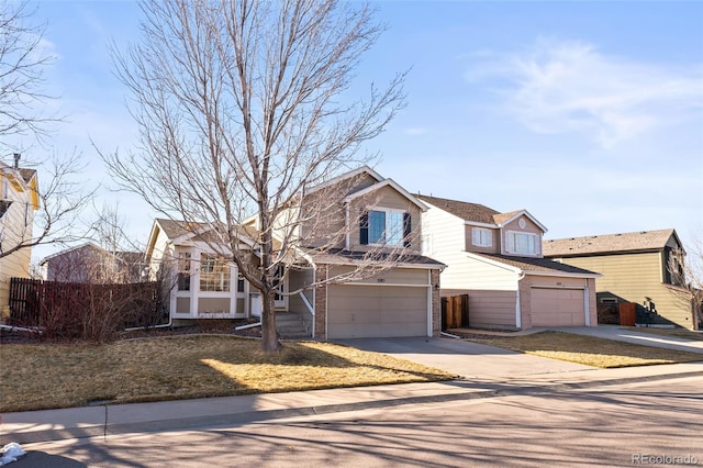 traditional home featuring brick siding, driveway, an attached garage, and fence