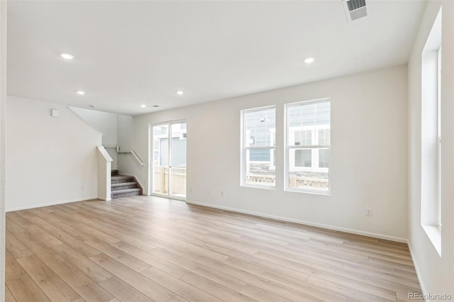 unfurnished living room with stairway, light wood finished floors, recessed lighting, and baseboards