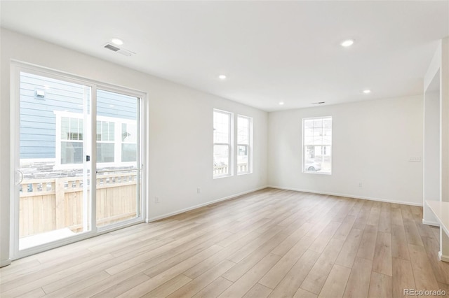 empty room with light wood-style flooring, baseboards, and recessed lighting