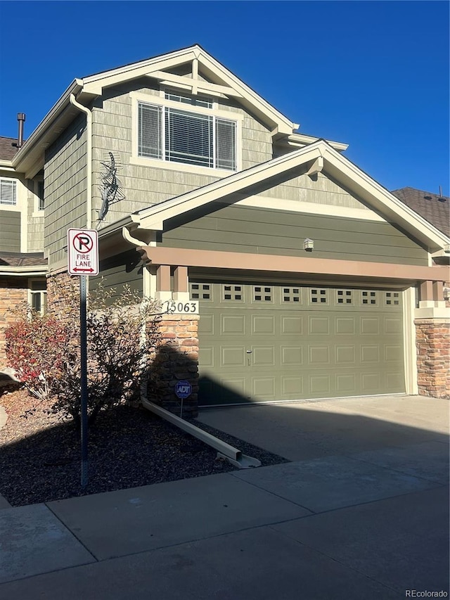 craftsman house with stone siding and driveway