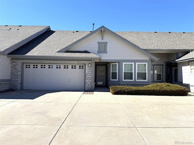 view of front facade with a garage, driveway, and a shingled roof