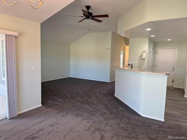 empty room with lofted ceiling, recessed lighting, dark carpet, ceiling fan, and baseboards