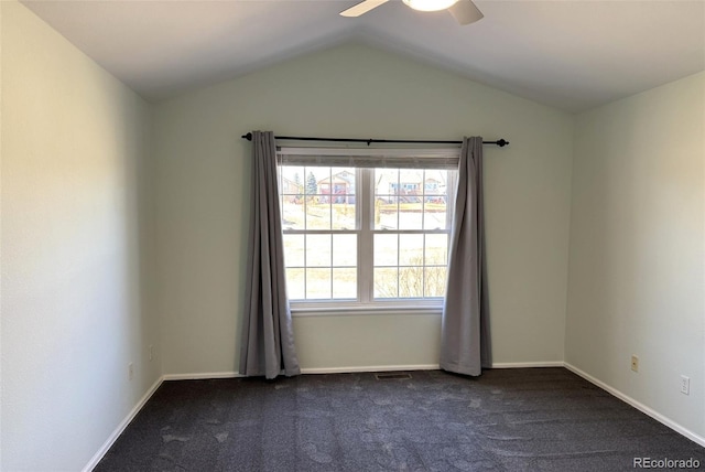 empty room with baseboards, visible vents, ceiling fan, vaulted ceiling, and dark carpet