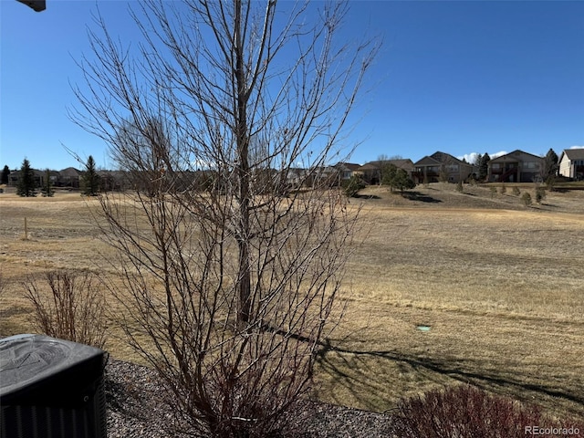 view of yard featuring a residential view and central AC