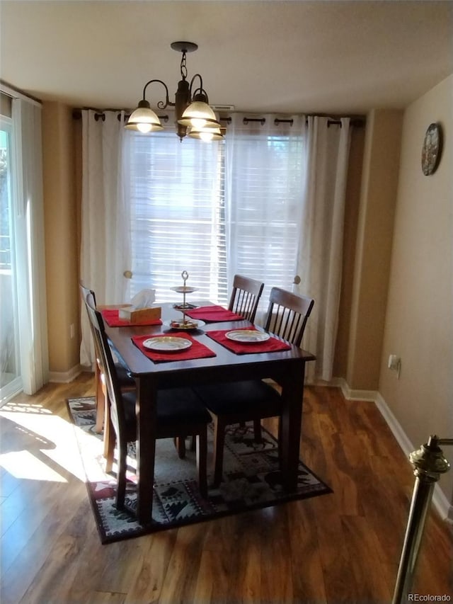 dining room featuring hardwood / wood-style floors and a chandelier