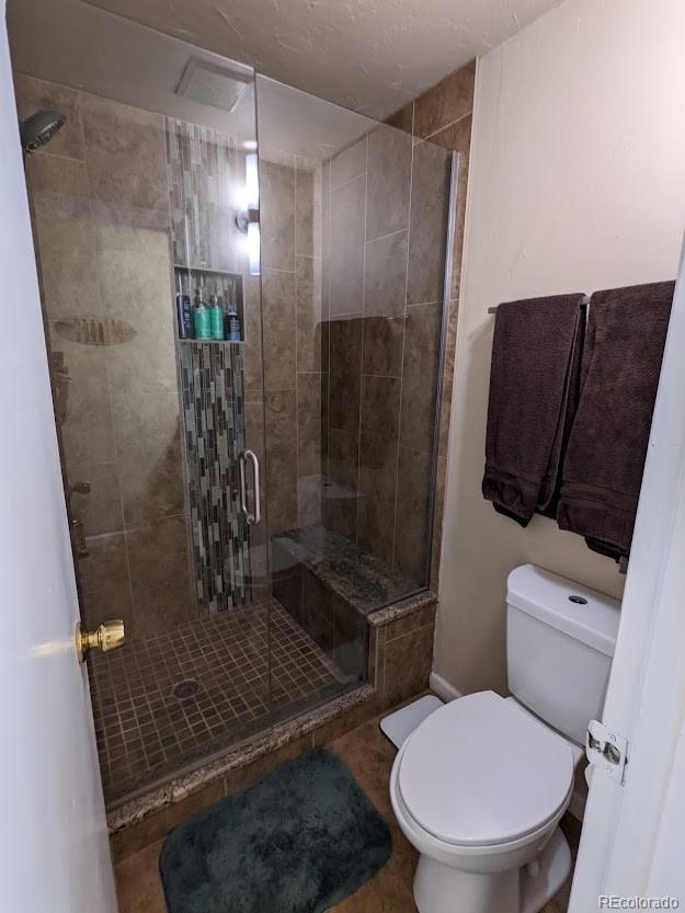 bathroom with toilet and a shower stall