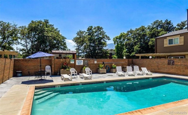 community pool featuring fence and a patio area